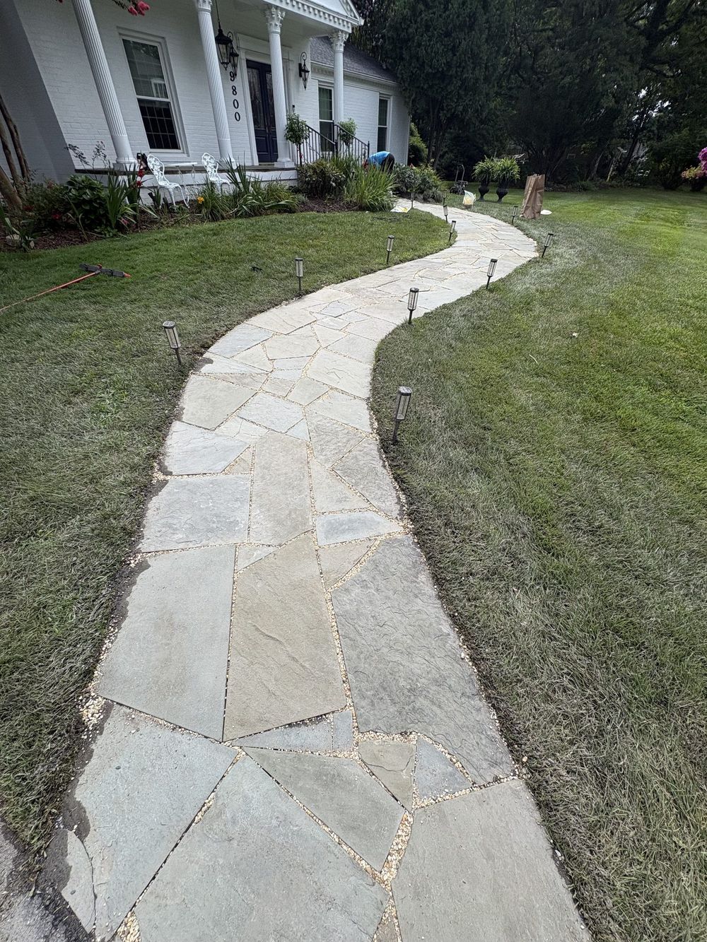 Flagstone walkway after pressure washing with joints refilled with decorative pebbles