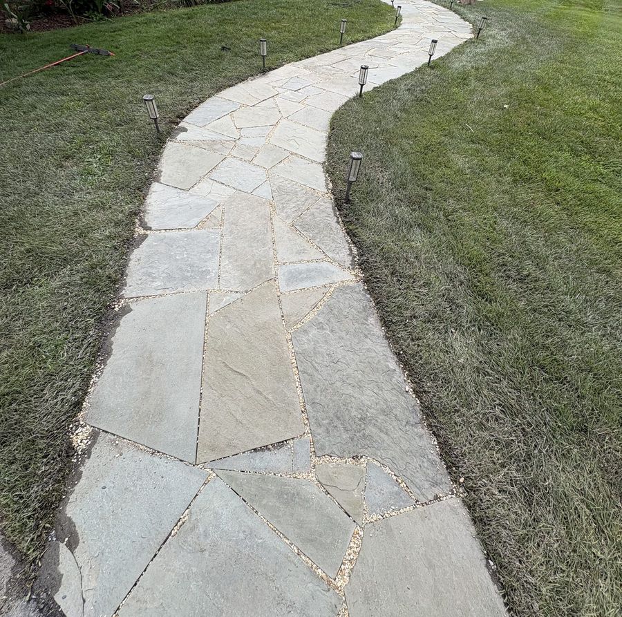 Flagstone walkway after pressure washing with joints refilled with decorative pebbles