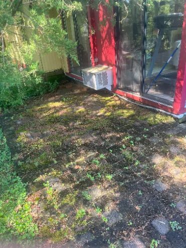 Paver patio covered in moss and grime before pressure washing